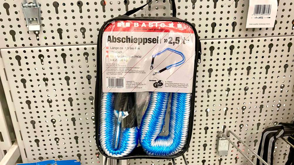 Ein verpacktes Abschleppseil für 2,5 t hängt zum testen an einem Löcherregal.