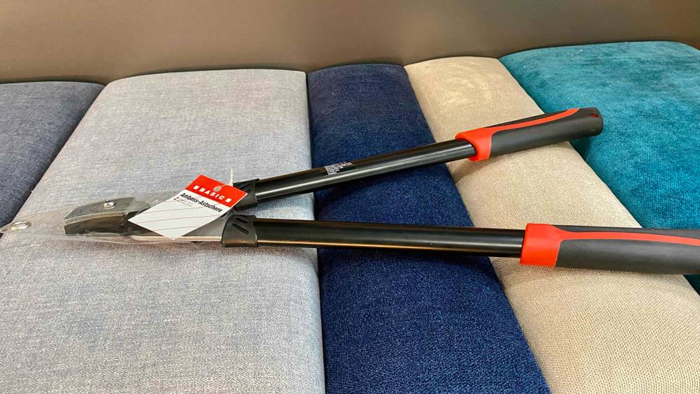 Amboss-Astschere getestet: Eine verpackte Schere von der Seite auf einem Polster liegend.