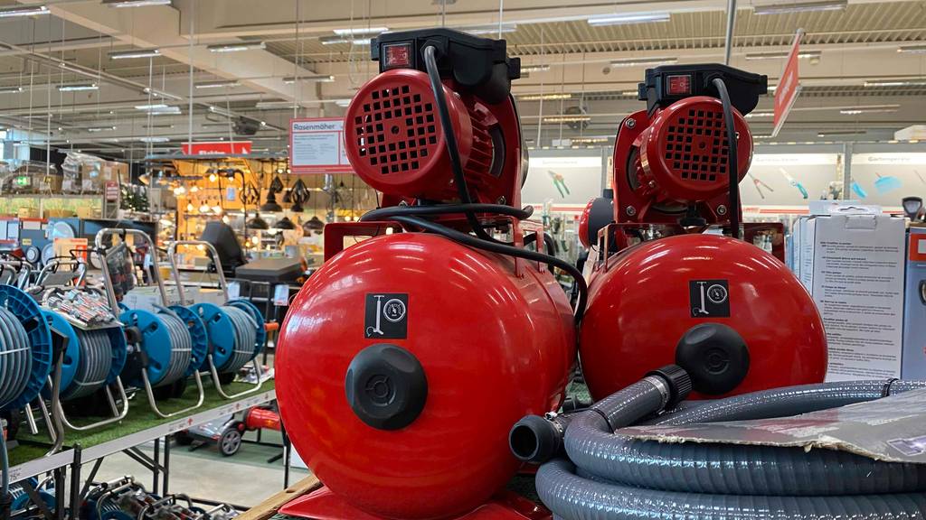 Hauswasserwerk-Test: zwei rote Modelle stehen in einem Geschäft mit Gartenbedarf.