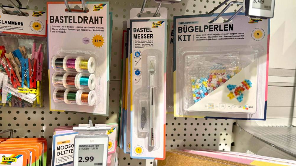In einem Verkaufsregal hängt ein Bastelmesser im Test neben anderen Produkten.