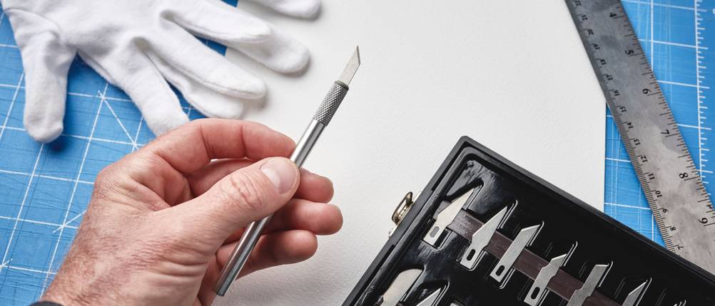 Bastelmesser-Test: Hand hält Bastelmesser, daneben Klingenset