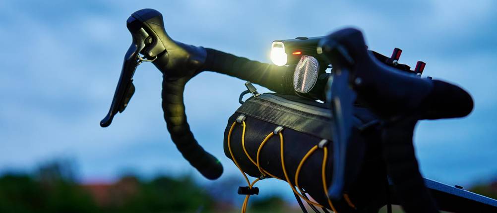 fahrradlampe-batterie-test: helle Fahrradlampe bei Nacht an einem Lenker.