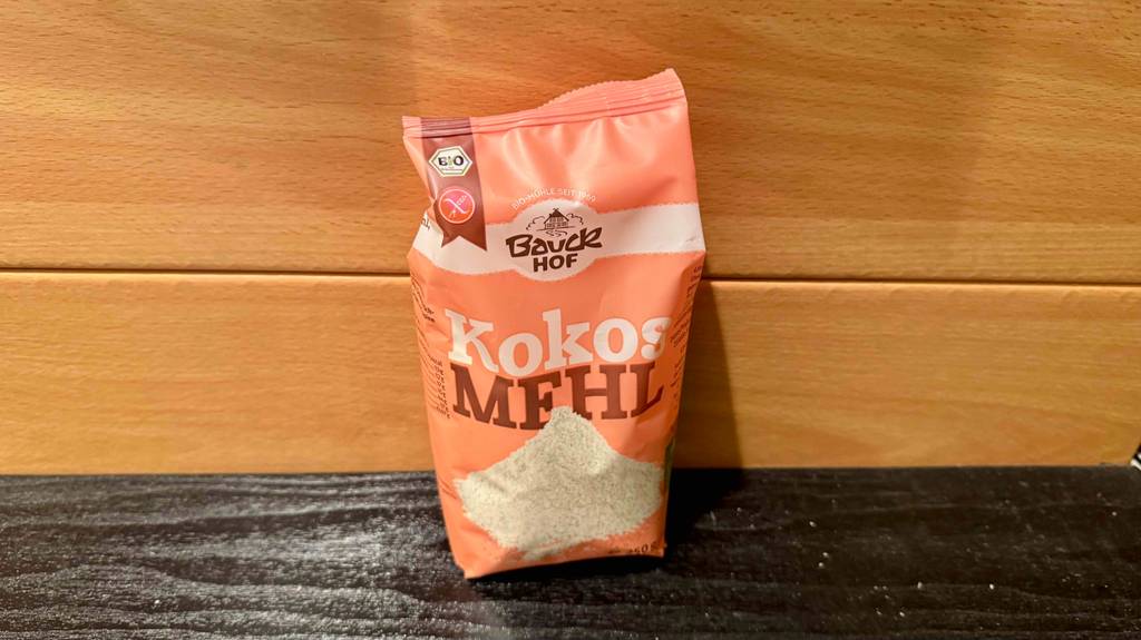 Kokosmehl-Test: Eine 250-g-Packung befindet sich vor einer Holzwand.