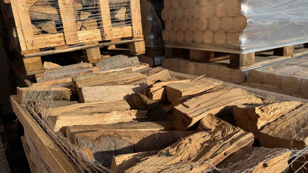 Eine Palette mit getestetem Brennholz steht geöffnet im Verkaufsbereich eines Baumarktes.