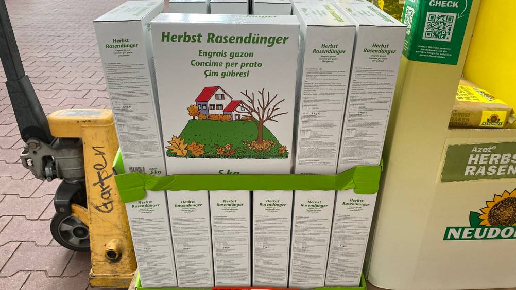 Eine Packung getesteter Herbstrasendünger von vorne neben anderen aufgestapelten.
