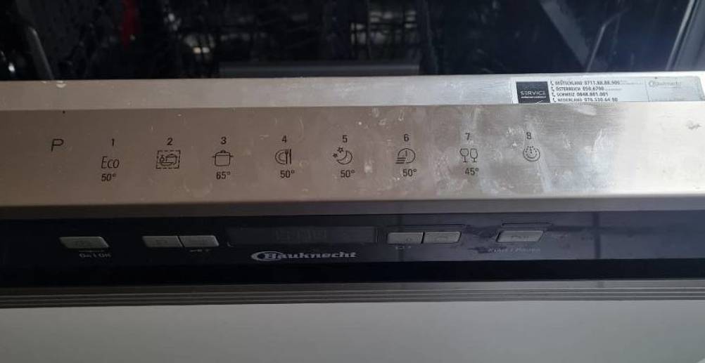 Bauknecht teilintegrierter Geschirrspüler im Test mit Fokus auf die Einschalttasten sowie die verschiedenen Spülprogramm-Symbole auf dem inneren, oberen Rand der Tür.