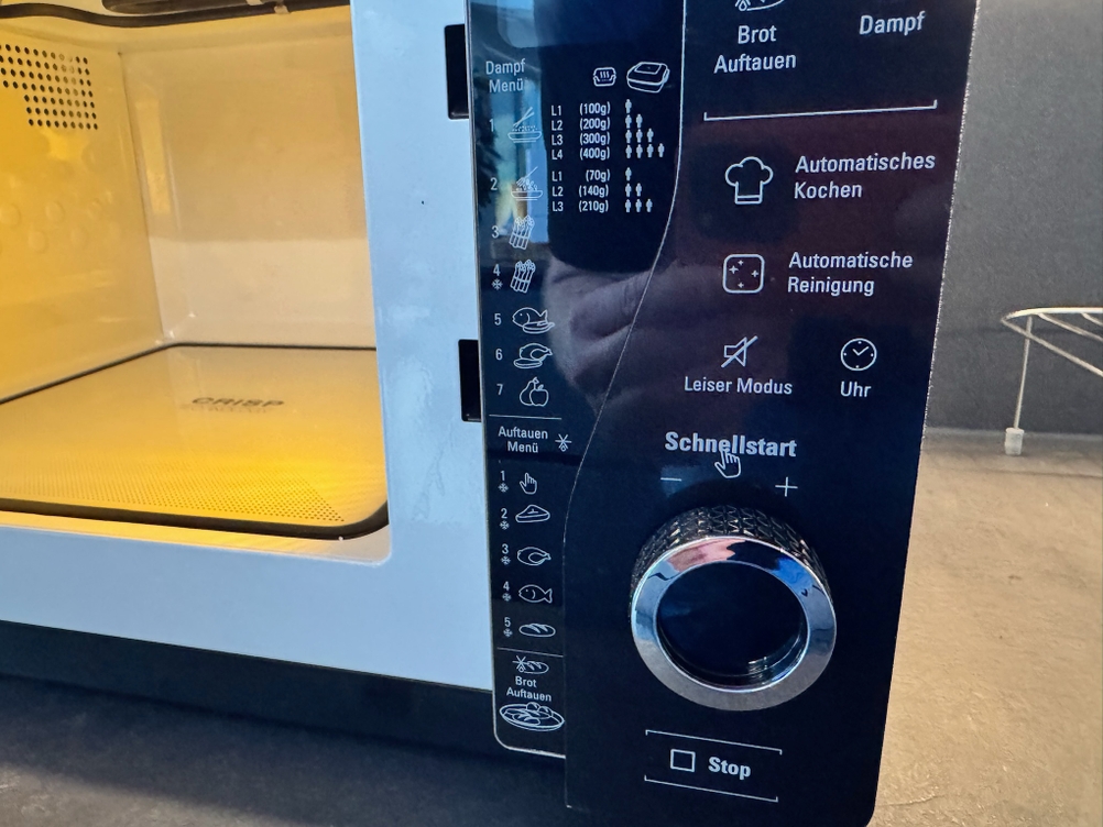 Bedienfeld und geöffnete Mikrowelle bei der Bauknecht ExtraSpace Crisp MW 427 SL