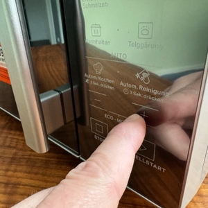 Ein Finger drückt auf das Bedienfeld der Bauknecht MW 254 SM