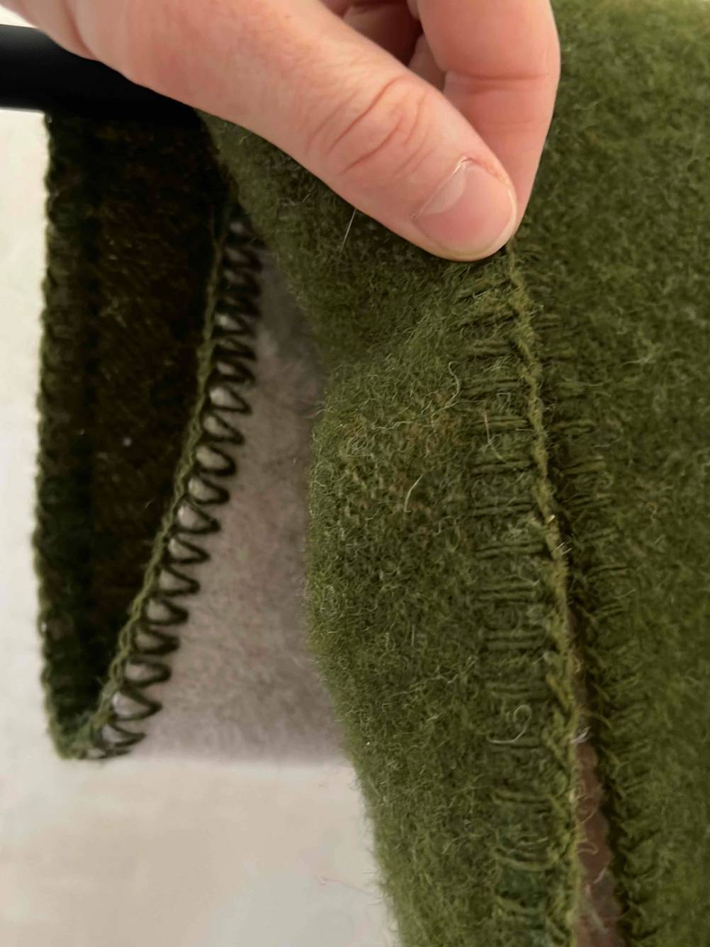 Baumwolldecke getestet: Nahaufnahme der Kantennaht die eine Hand zwischen den Fingern hält.