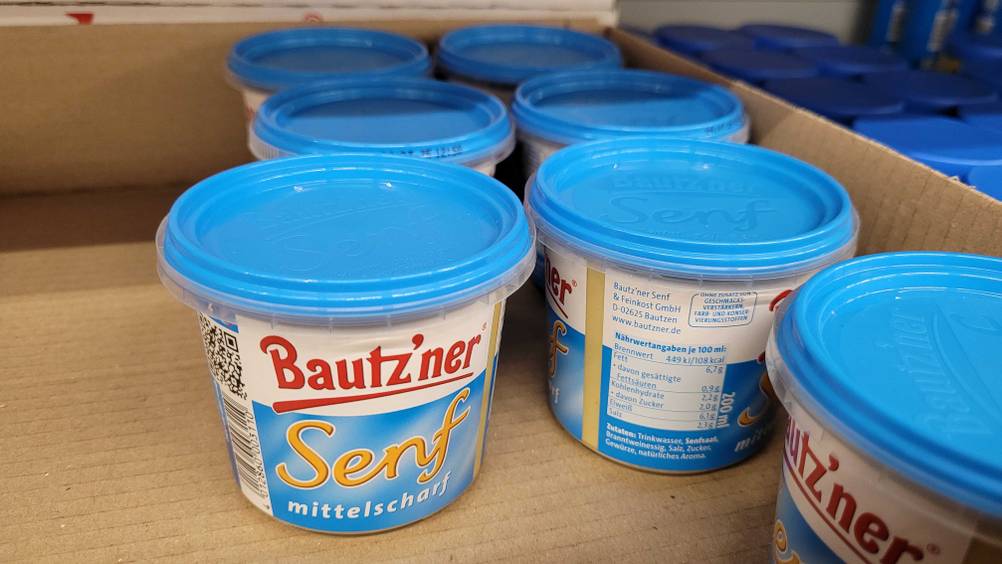 Mehrere Tiegel des Bautz'ner Senfs im Test in einem Karton von schräg oben.