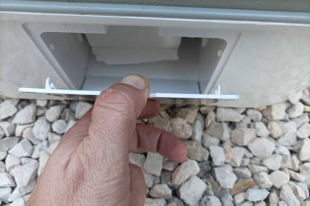 Campingtoilette im Test: Hand öffnet Fach für Toilettenpapier.