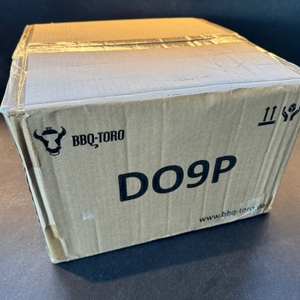 Der Karton des BBQ-Toro DO9P steht auf einem Tisch