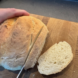 Mit einem Messer wird Weißbrot aus dem BBQ-Toro DO9P geschnitten