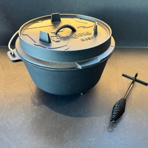 Der BBQ-Toro DO9P steht neben dem Deckelheber auf einem Tisch