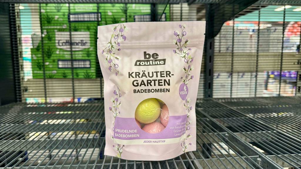 Badebomben-Test: Eine wiederverschließbare Tüte mit sprudelnden Badebomben steht auf einem Regalgitter.
