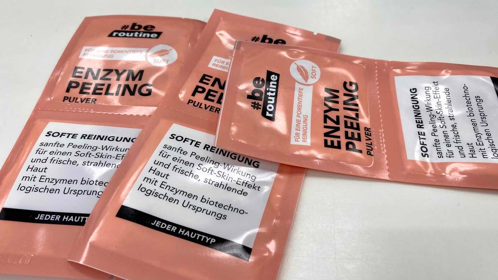 Zwei Packungen Enzympeeling der Marke be routine liegen auf einem weißen Untergrund, eine dritte liegt quer darüber.