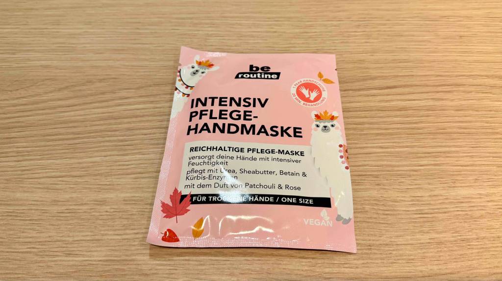 Eine Packung getestete Handmaske liegt auf einer Holzfläche.