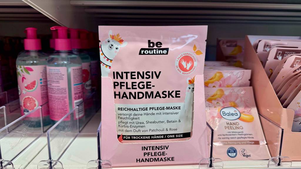 Handmaske im Test: Mehrere Packungen stehen in einem Karton zwischen anderen Produkten in einem Regal.