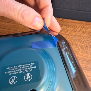 Eine Hand zieht einen Klebestreifen vom Bear ‎JSQ-F50D2