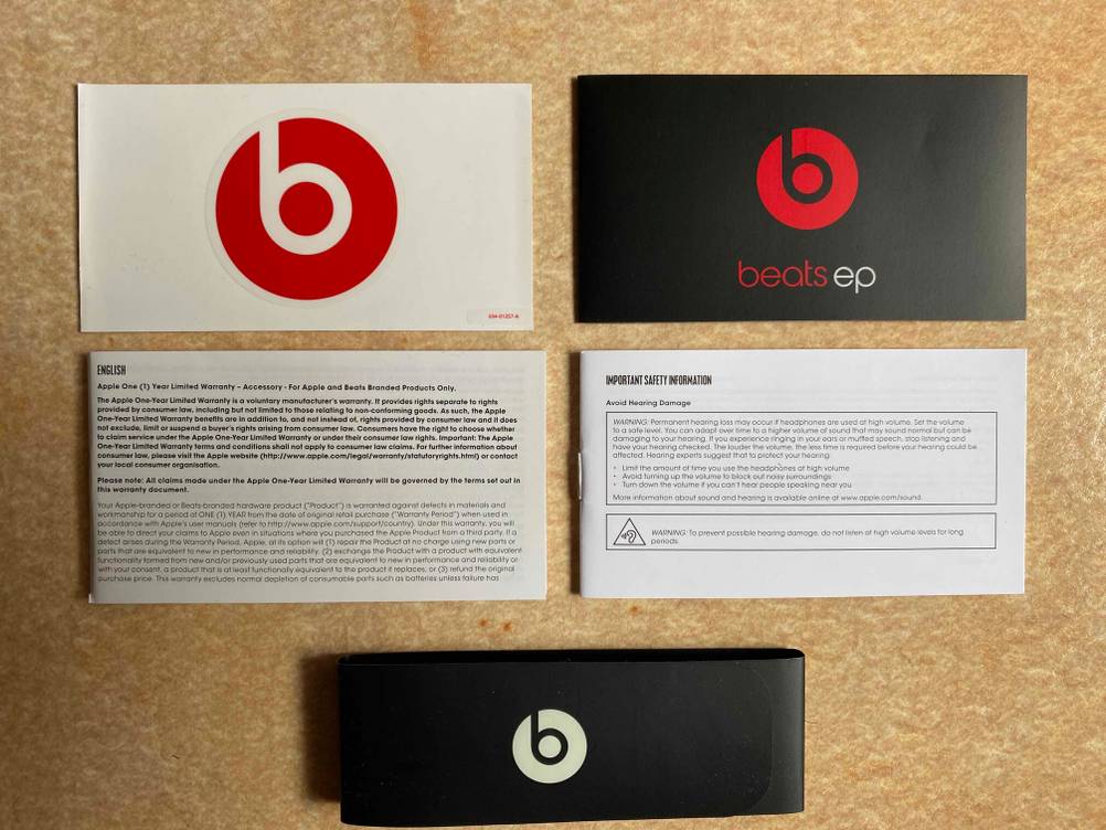 Beats-Kopfhörer getestet: Alle beigefügten Unterlagen einer Packung Beats-Kopfhörer aufgereiht auf einer Holzfläche.