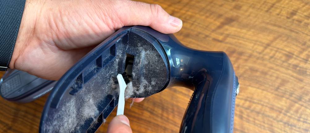 Fussel werden mit einer Reinigungsbürste aus dem Beautural ISJKL9889748 entfernt