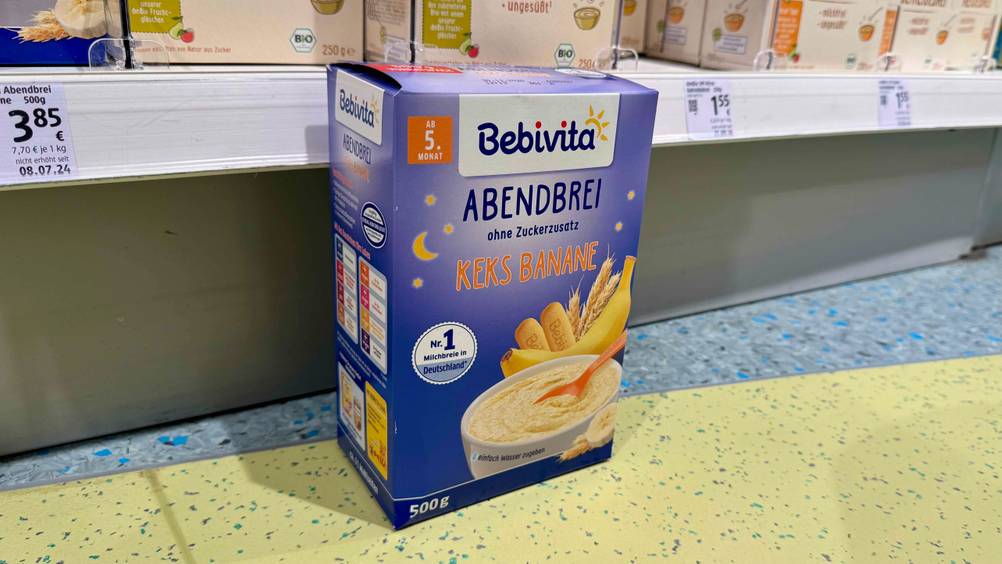 Vor einem Verkaufsregal mit Preisschildern steht auf dem Boden eine Packung des getesteten Bebivita-Brei.