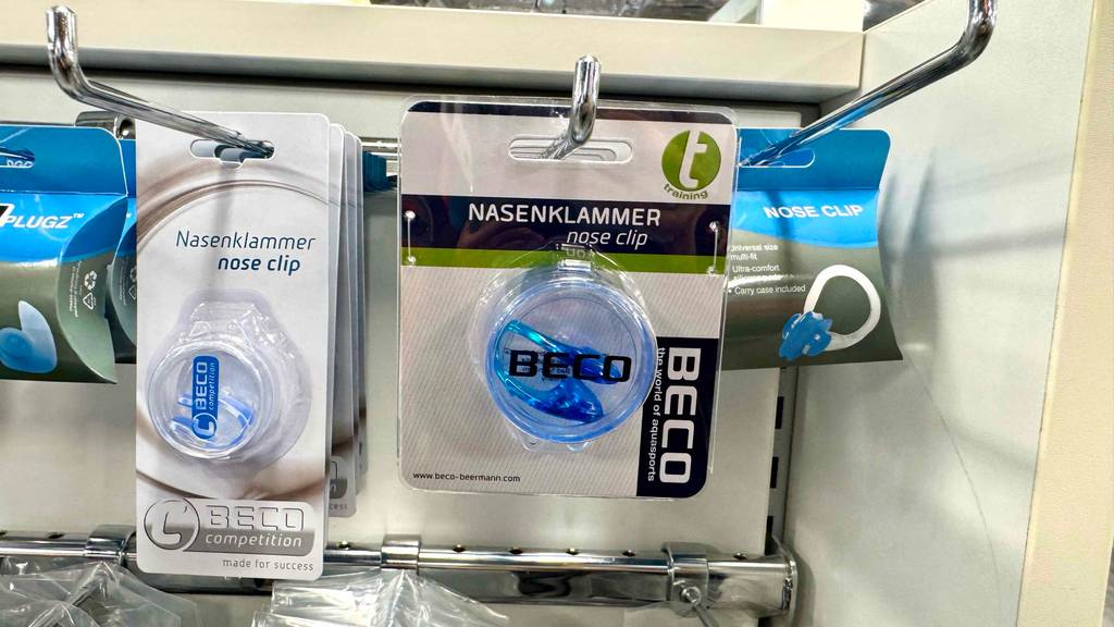 Nasenklammer zum Schwimmen im Test: Mehrere Packungen in verschiedenen Ausführungen hängen in einem Regal.