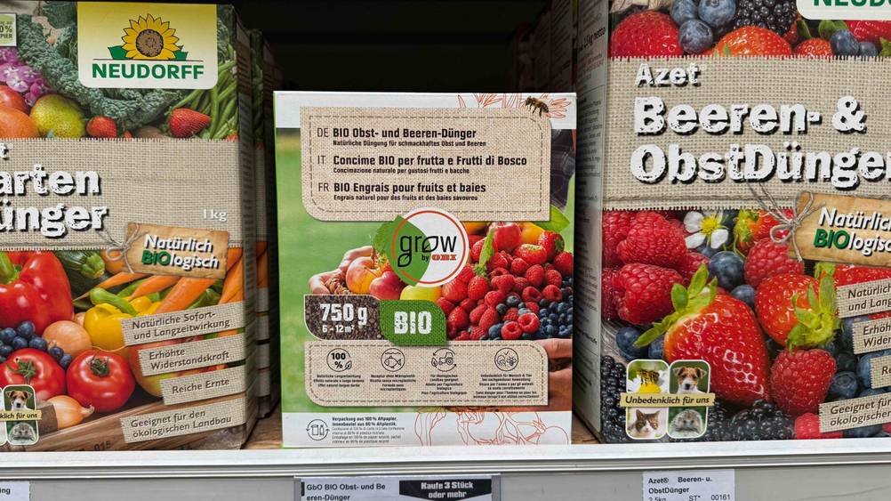 In einem Regal steht eine Packung des Beerendüngers im Test neben anderen Marken.