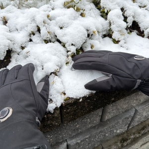 Eine Person greift Schnee mit den beheizbaren Aroma-Season-Handschuhen
