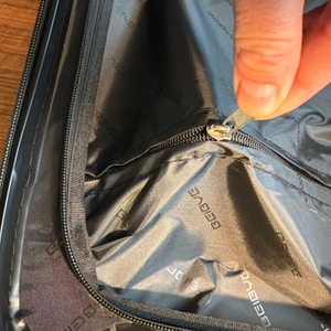 Eine Hand zieht an einem Reißverschluss des Beibye 2045