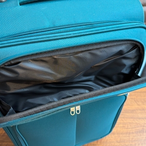 Eine Hand öffnet ein Fach außen am Beibye-4-Rollen-Reisekoffer