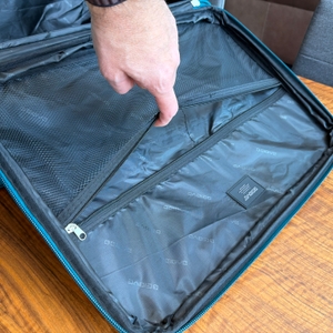 Eine Hand öffnet ein Fach im Inneren vom Beibye-4-Rollen-Reisekoffer