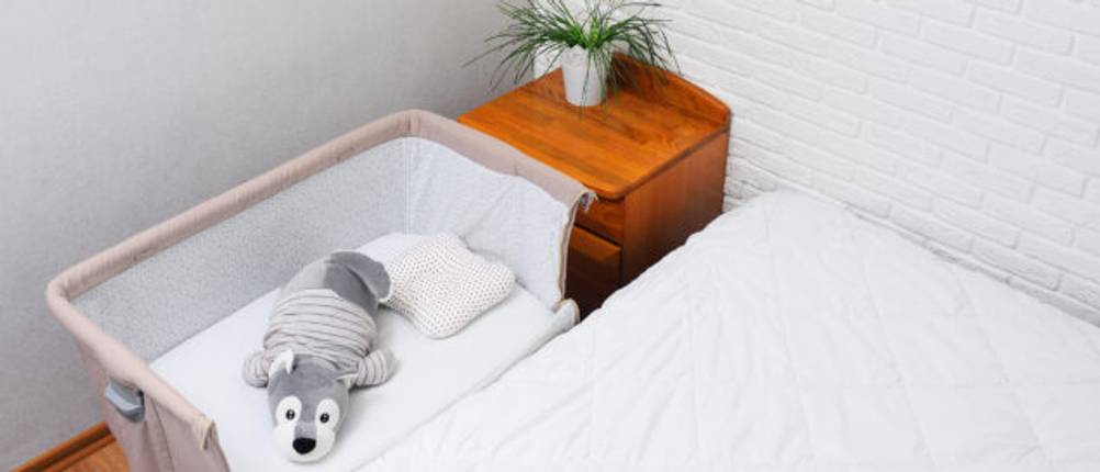 Beistellbett Boxspring Test: Rosa Beistellbett aus Stoff mit Kuscheltier an Bett