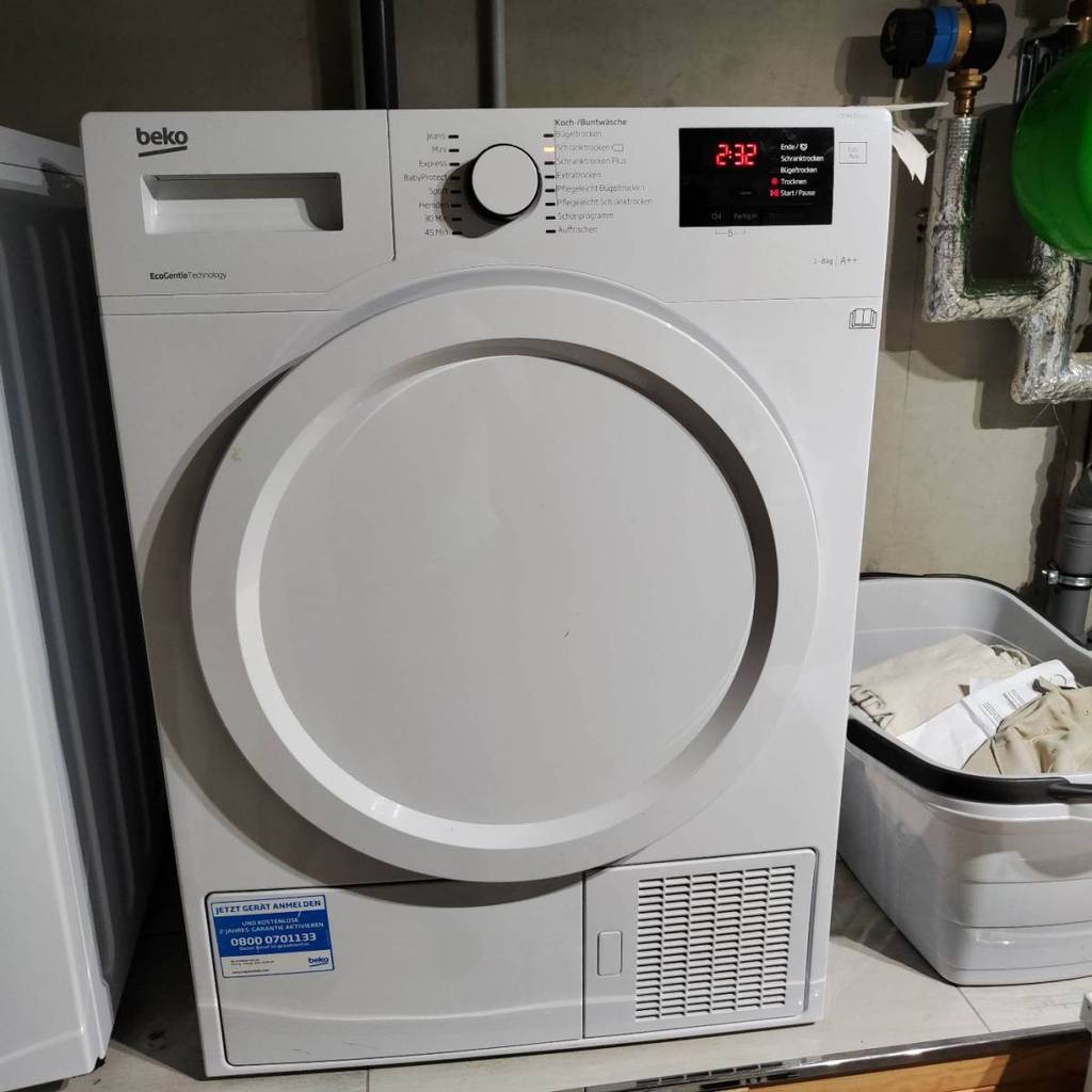 Kondenstrockner-Test: Nahaufnahme von einem weißen eingeschalteten Beko Frontlader in einem Hauswirtschaftsraum.