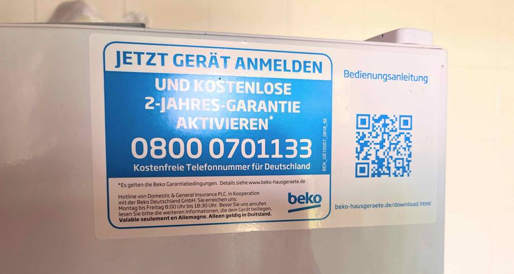 Beko-Kühlschrank-Test: Detailansicht des blauen Geräte-Aufklebers inklusive QR-Code und kostenfreier Service-Telefonnummer.