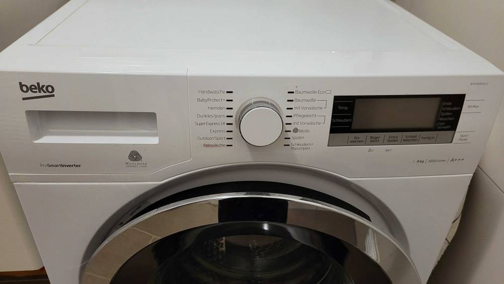 Blick auf die Menüleiste mit Display und Einstellrad sowie Waschmittelfach einer getesteten Beko-Waschmaschine.