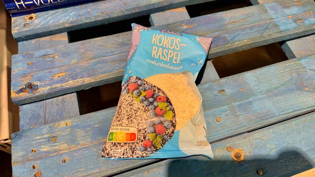 Eine Packung getestete Kokosraspeln liegt auf einer blauen Palette.