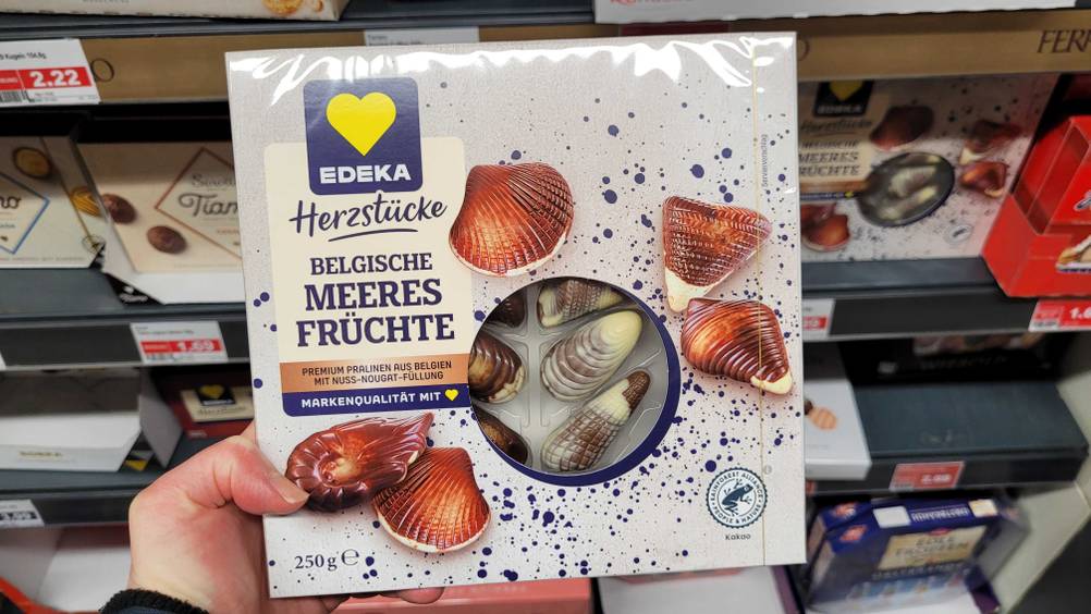 Eine Hand hält eine Packung der getesteten belgischen Pralinen.