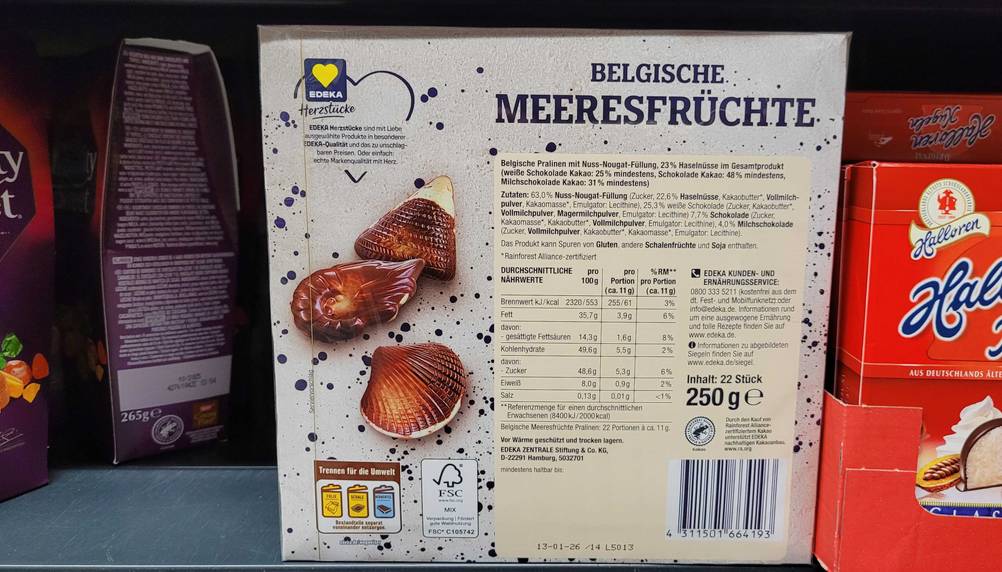 Eine Packung der belgischen Pralinen in einem Verkaufsregal mit der Rückseite nach vorne.