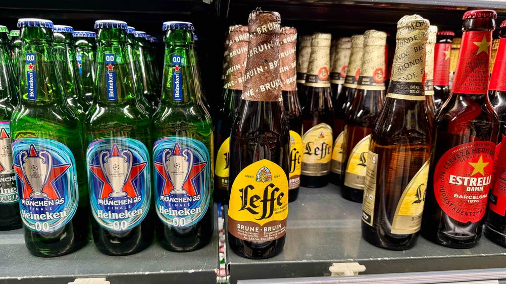 Belgisches Bier im Test: Mehrere Flaschen stehen neben anderen Produkten in einem Regal.