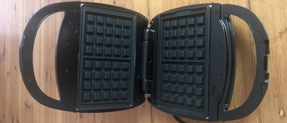 Ein geöffnetes Waffeleisen mit Waffelblechen in Draufsicht.