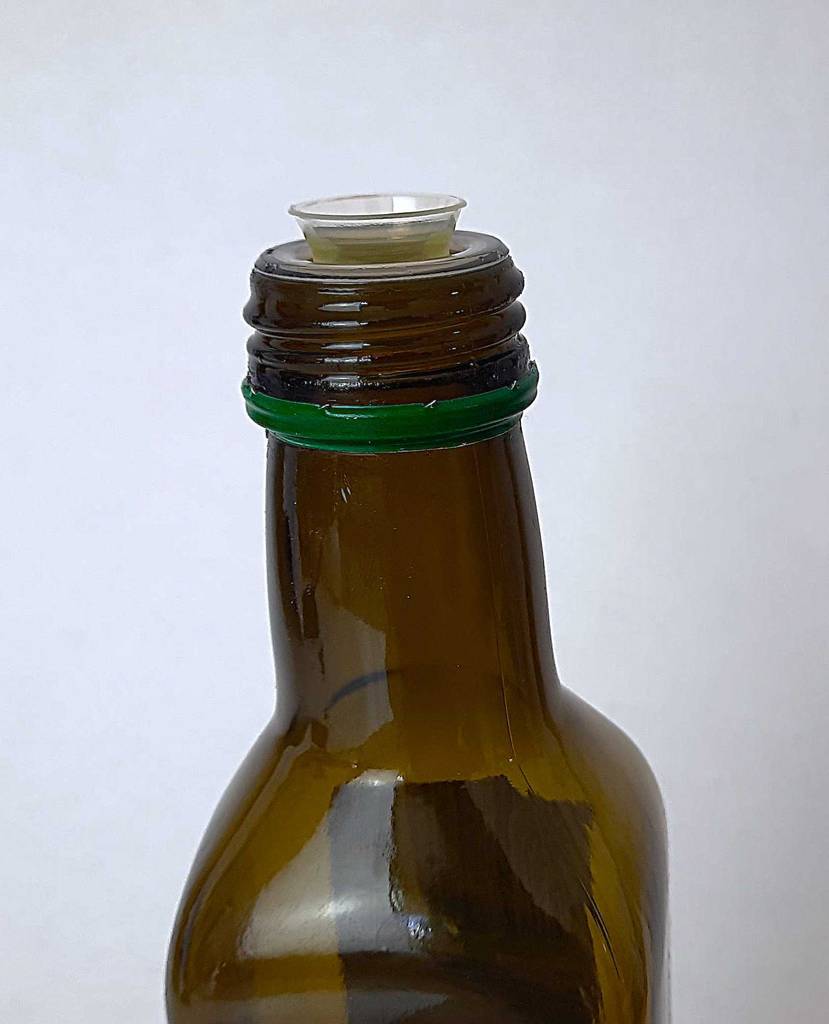 Detailansicht des Ausgießers einer geöffneten Flasche getestetes Speiseöl.