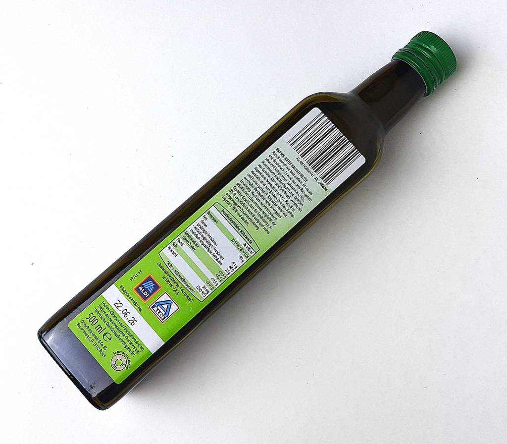 Eine Flasche getestetes Speiseöl liegt mit der Rückseite nach oben auf einer weißen Fläche.