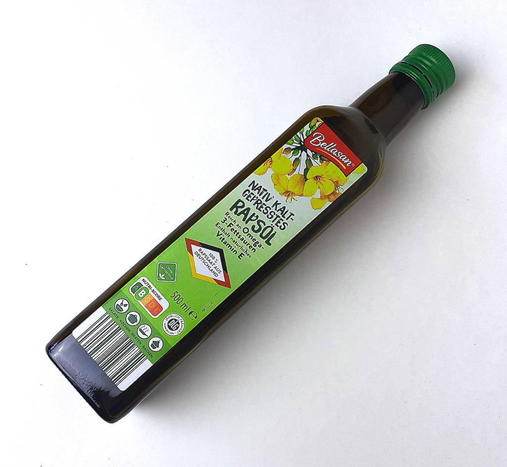 Eine Flasche Speiseöl liegt zum testen auf einer weißen Fläche.