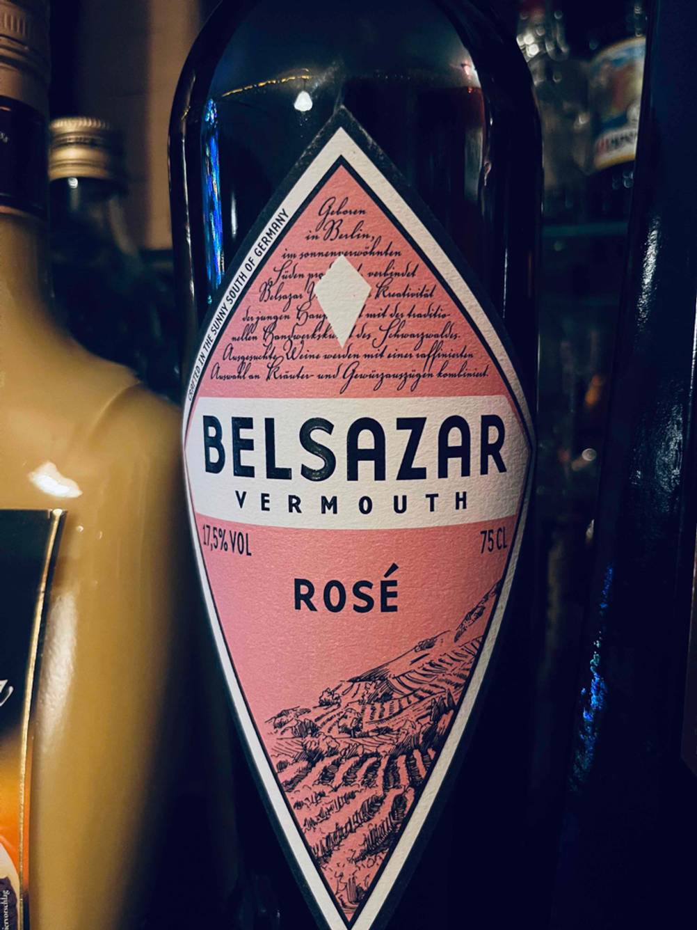 Detailansicht vom vorderen Etikett eines Belsazar Vermouths im Test neben anderen alkoholischen Getränken.