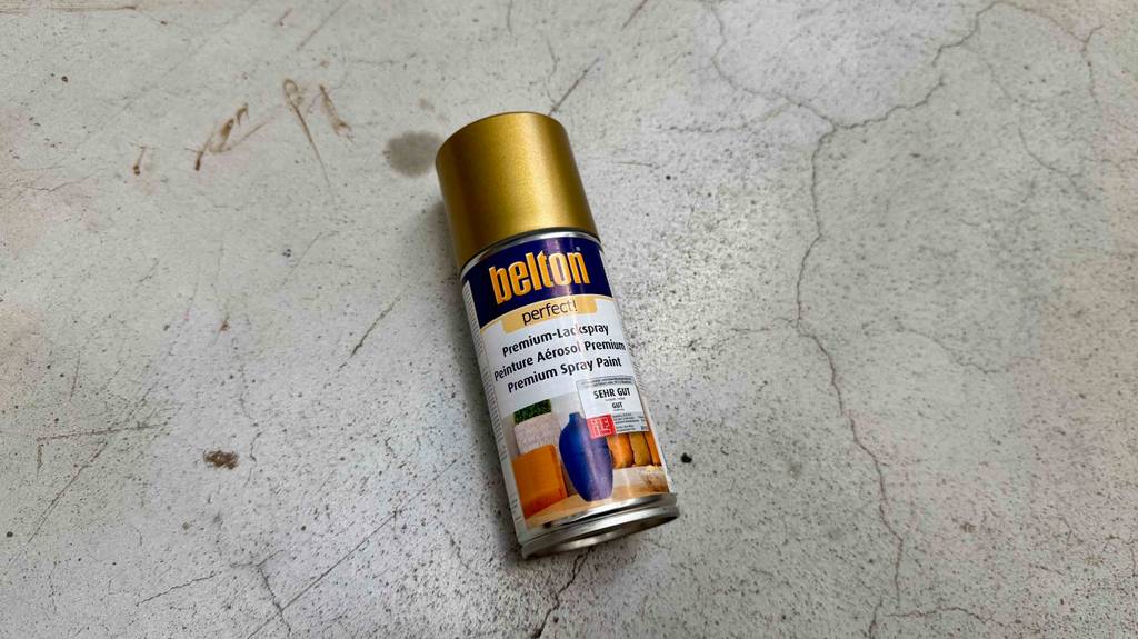 Goldspray getestet: Eine Spraydose liegt auf einem Zementboden.