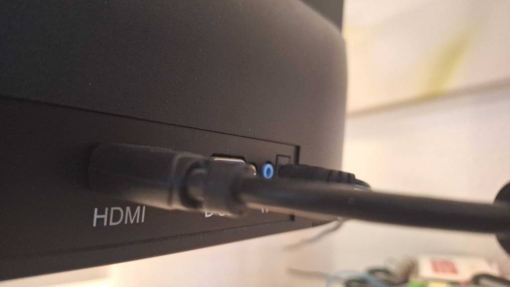 Nahaufnahme eines schwarzen, getesteten HDMI-2.1-Kabels, das in einer HDMI-Buchse steckt.