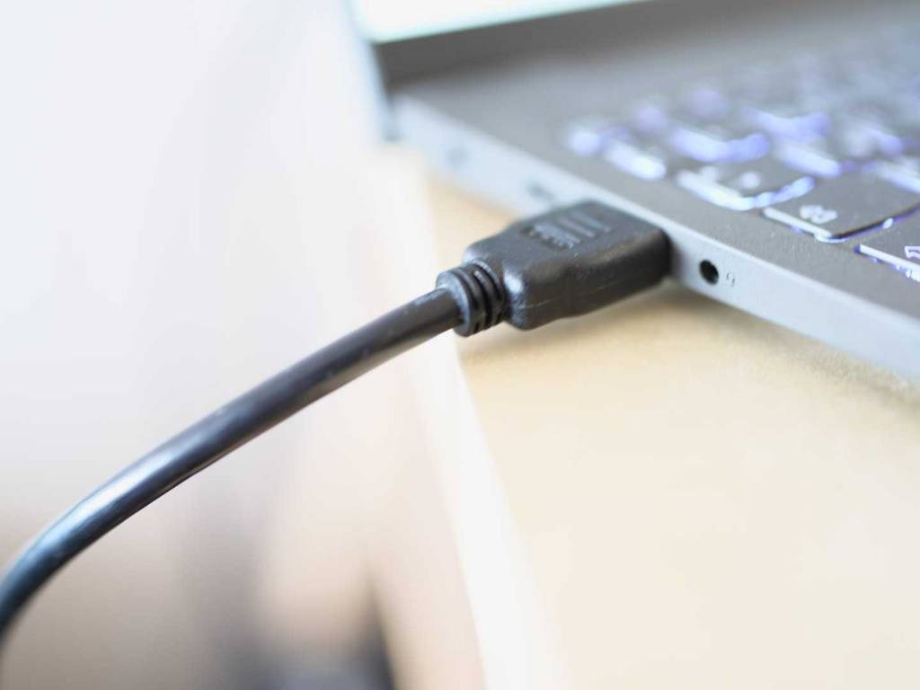 HDMI-2.1-Kabel-Test: Nahaufnahme des Anschlusses eines schwarzen Kabels, das in einem Laptop steckt.