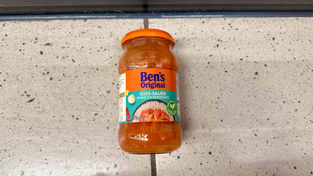 Auf einem Fließenboden liegt ein Glas der getesteten Bens Original Sauce.