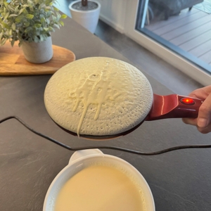 Eine Hand hält den Beper BT.710Y fest, während ein Crêpe auf ihm liegt